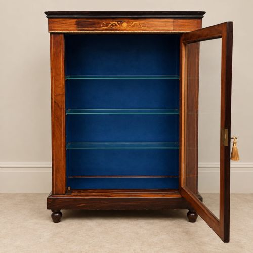 fig 2. A late 19th-century Victorian rosewood pier cabinet featuring a glazed single door, brass beaded moulding, inlaid foliate marquetry, and a blue fabric-lined interior with glass shelves.