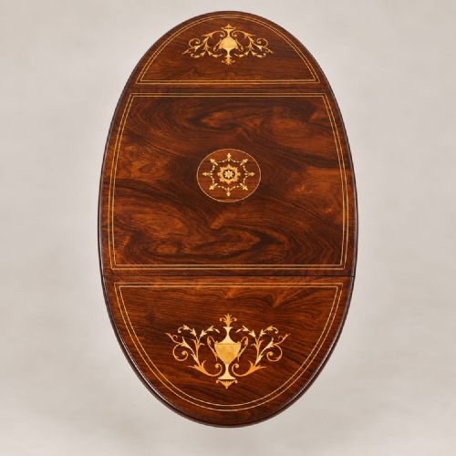 fig 2. A Victorian rosewood drop leaf occasional table featuring marquetry floral inlay on the drawer, slender cabriole legs, and a lower shelf with a central inlaid medallion.