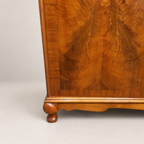 fig 1. A 1920s burr walnut triple wardrobe featuring three doors with book-matched figure patterns and short cabriole feet.