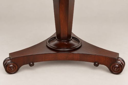 fig 2. An antique circular William IV rosewood tilt-top dining table with a polished surface, central column stem, and triform plinth base with carved scroll feet.