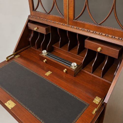 fig 1. An Edwardian Chippendale Revival mahogany bureau bookcase featuring an upper glazed cabinet, slant-front writing desk with flame mahogany oval inlay, lower drawers, and cabriole legs with ball-and-claw feet.