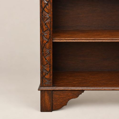 fig 2. A dark oak open bookcase dating to circa 1920 featuring carved lunette moulding along the upper frieze and three internal storage shelves.