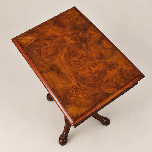 fig 2. A Victorian burr walnut work table featuring a hinged rectangular top, conical trumpet well, turned central column, and four carved cabriole legs.