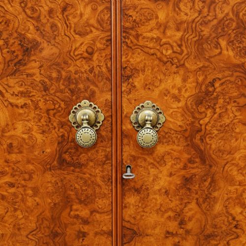 fig 1. A 1920s double wardrobe crafted from burr walnut featuring an arched cornice, twin doors with brass hardware, and turned feet.