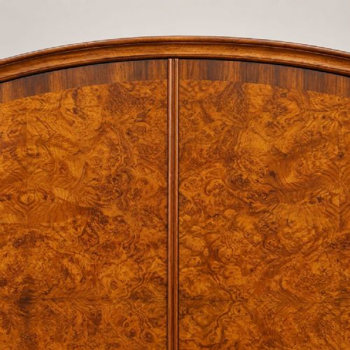 fig 2. A 1920s double wardrobe crafted from burr walnut featuring an arched cornice, twin doors with brass hardware, and turned feet.