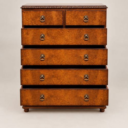 fig 2. A 1920s burr walnut chest of drawers featuring five drawer tiers with brass drop handles and carved cabriole legs.