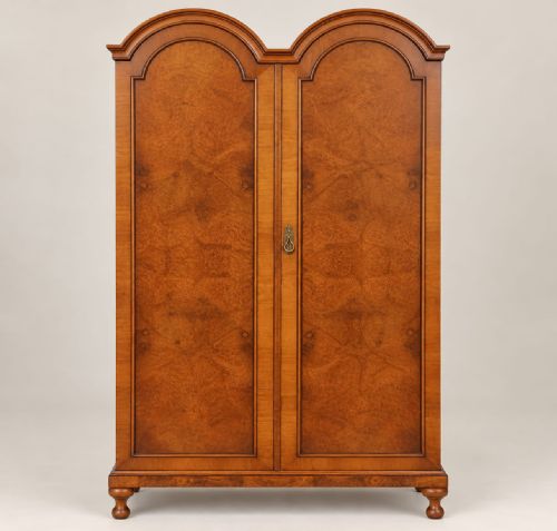 fig 1. A 1920s burr walnut double wardrobe with a double-domed top, twin arched panel doors, and short shaped feet.