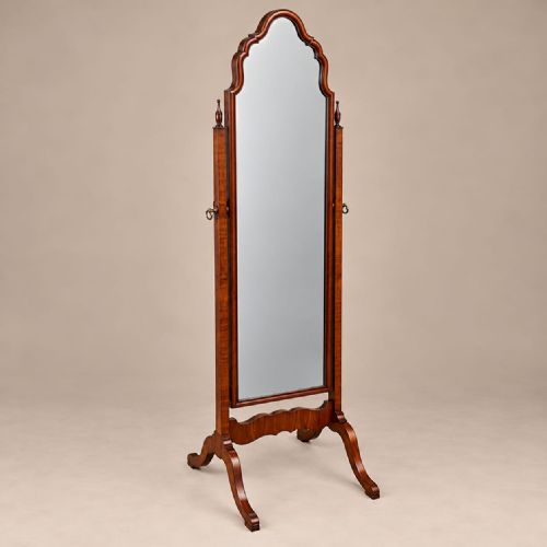 fig 2. A full-length 1920s burr walnut cheval mirror featuring a shaped arched top frame, twin side uprights topped with turned finials, and splayed legs.