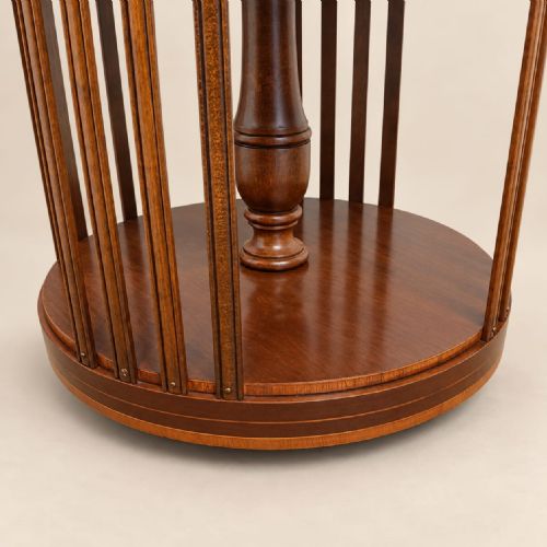 fig 1. A circular mahogany three-tier revolving bookcase featuring vertical slatted sides, central turned columns, and a rotating base mounted on small castors.