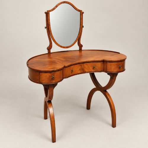fig 1. A 1920s kidney-shaped timber dressing table featuring three drawers, sweeping curved legs, and an attached shield-shaped swivel mirror.