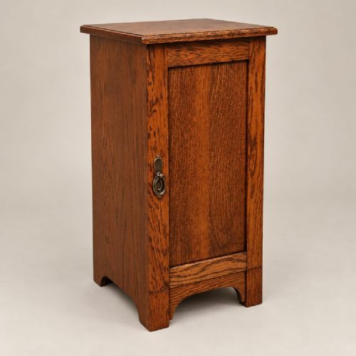 fig 2. A pair of medium oak bedside cabinets featuring single panelled doors, brass teardrop handles, and shaped aprons.