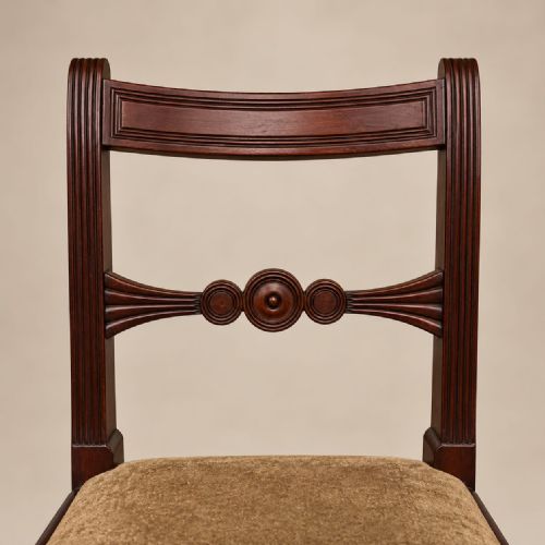 fig 2. A set of six George III mahogany dining chairs featuring carved roundel back splats, turned front legs, and neutral upholstered seats.