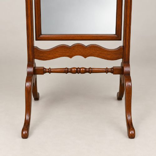 fig 1. A 1920s full-length mahogany cheval mirror featuring an arched top frame, upright side posts with finials, turned cross-stretcher, and splayed feet.