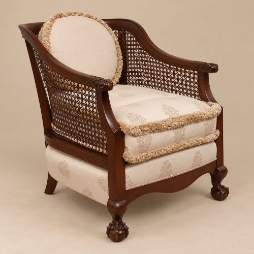 fig 1. A pair of 1920s mahogany tub chairs featuring woven cane side panels, carved claw and ball feet, and cream upholstered cushions with matching circular accent pillows.