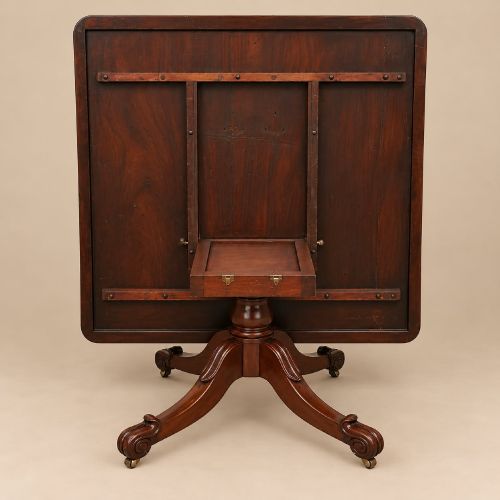 fig 1. A late Georgian mahogany tilt-top dining table featuring a central turned pedestal and splayed quadform legs with brass castors.