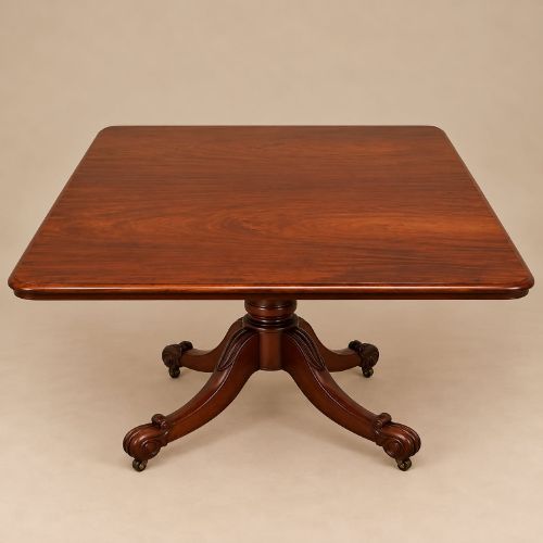 fig 2. A late Georgian mahogany tilt-top dining table featuring a central turned pedestal and splayed quadform legs with brass castors.