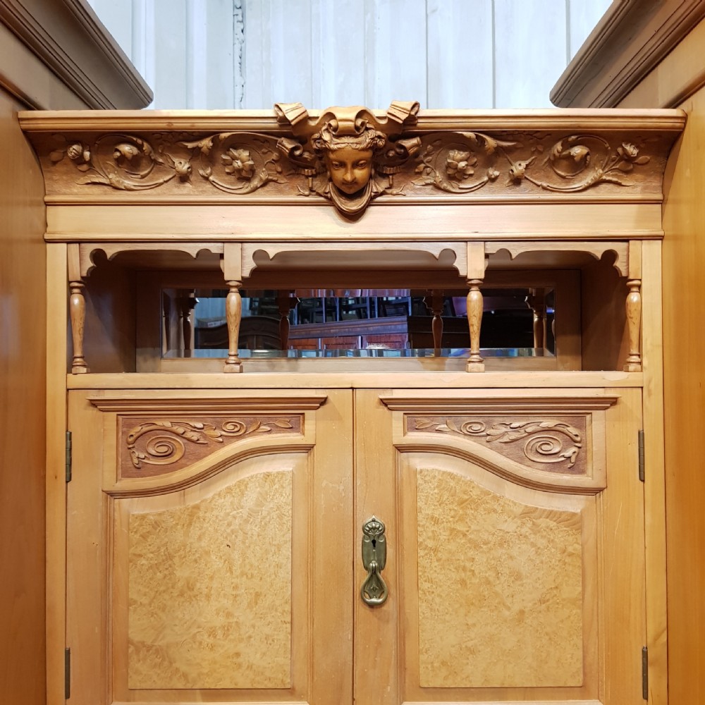 An antique Victorian satin walnut and maple combination wardrobe featuring two tall outer sections with mirrored doors flanking a central chest of drawers and small upper cupboard. View VIII
