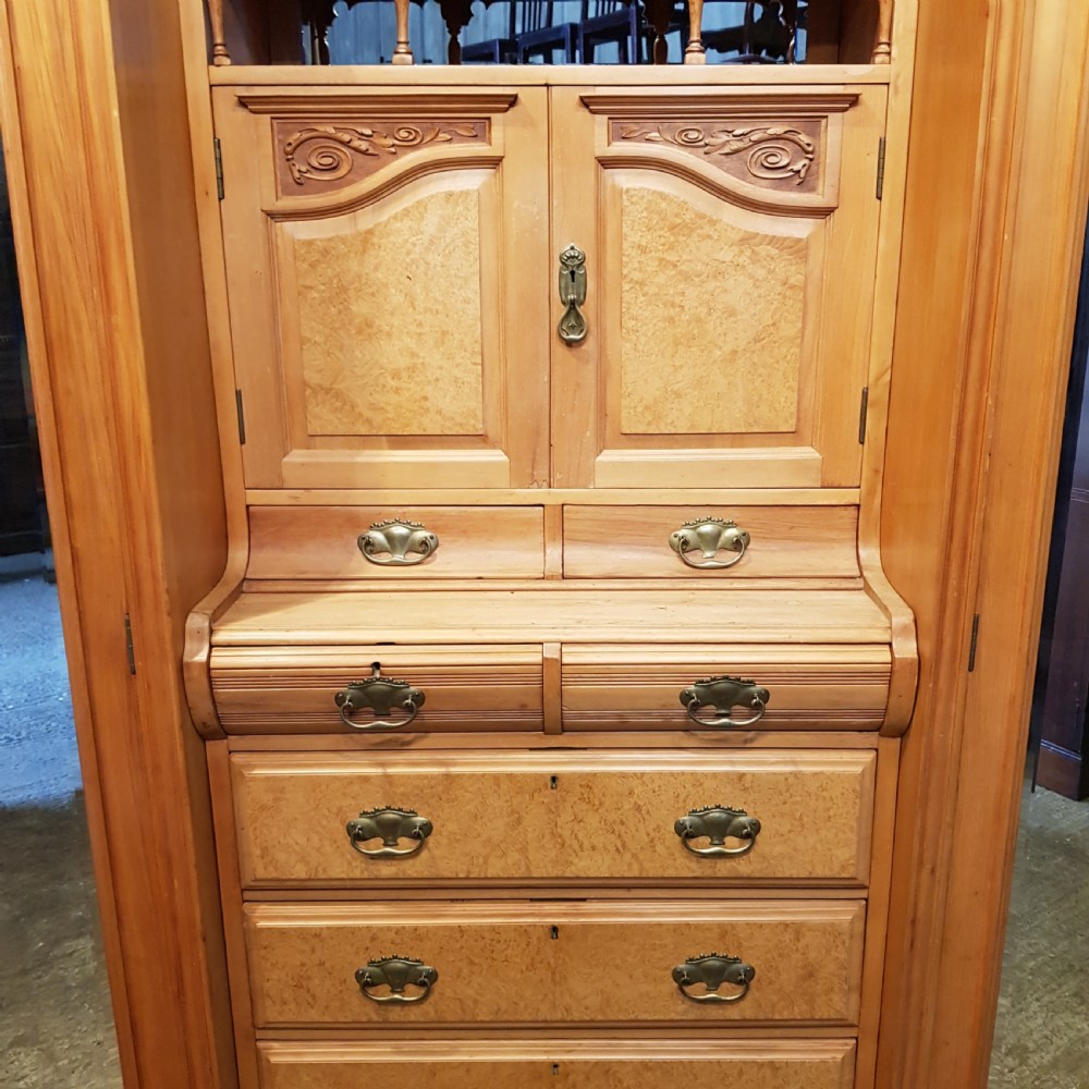 An antique Victorian satin walnut and maple combination wardrobe featuring two tall outer sections with mirrored doors flanking a central chest of drawers and small upper cupboard. View XI