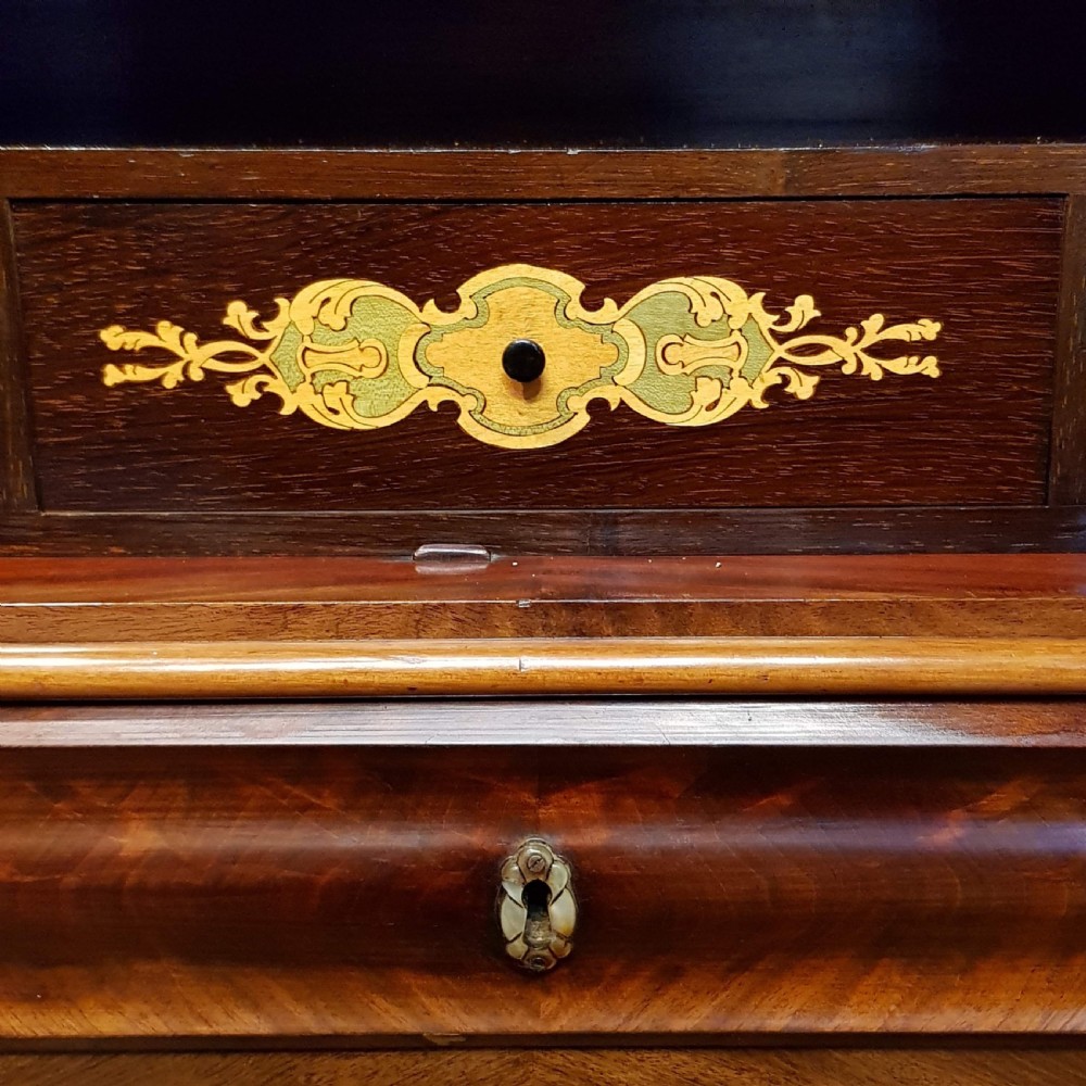 A nineteenth-century Biedermeier flame mahogany tall storage cabinet featuring double upper doors with figure-matched veneer and three full-width lower drawers. View V