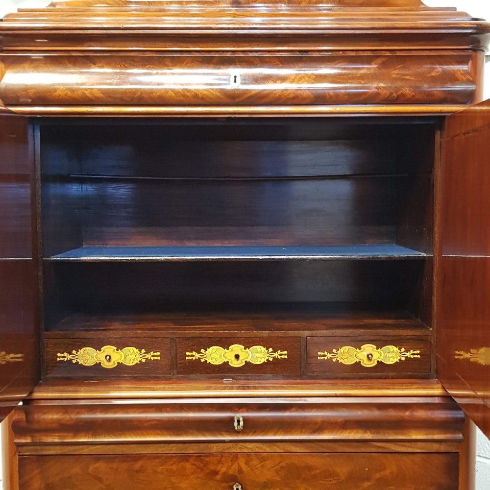 A nineteenth-century Biedermeier flame mahogany tall storage cabinet featuring double upper doors with figure-matched veneer and three full-width lower drawers. View VI
