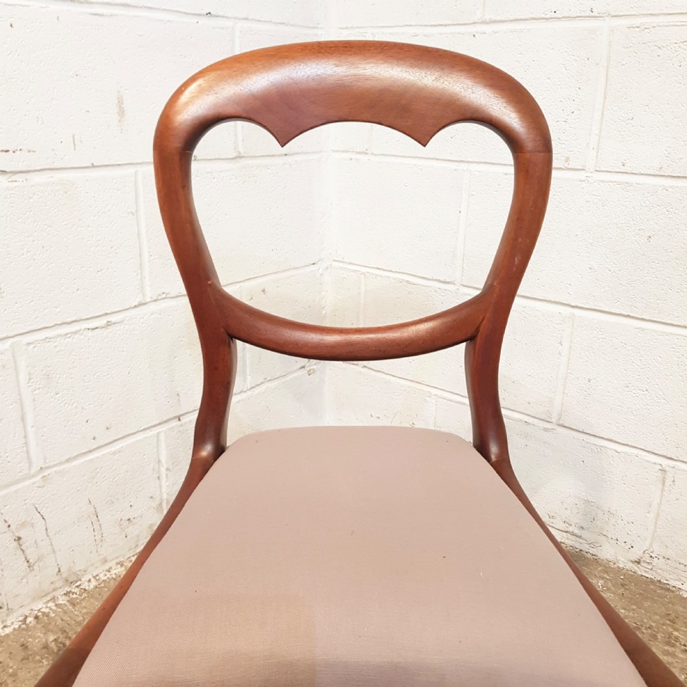 A set of six Victorian mahogany dining chairs featuring open balloon back frames, turned front legs, and neutral upholstered seats. View V
