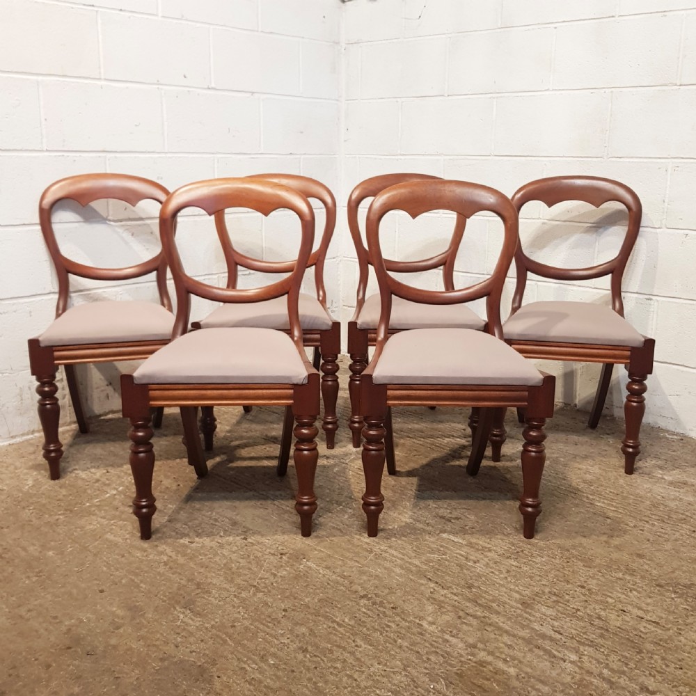 A set of six Victorian mahogany dining chairs featuring open balloon back frames, turned front legs, and neutral upholstered seats. View XII