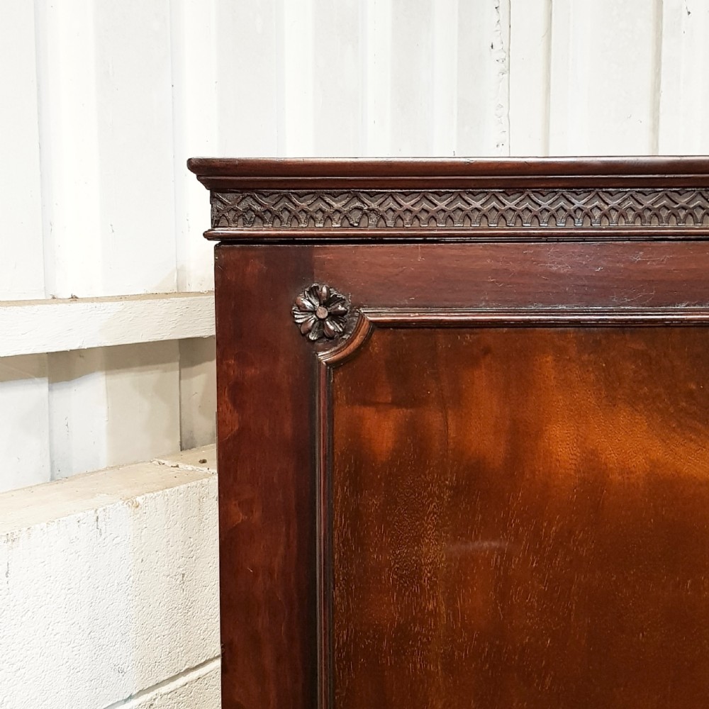 An eighteenth-century mahogany double wardrobe featuring flame mahogany panel doors decorated with carved corner rosettes and resting on bracket feet. View V