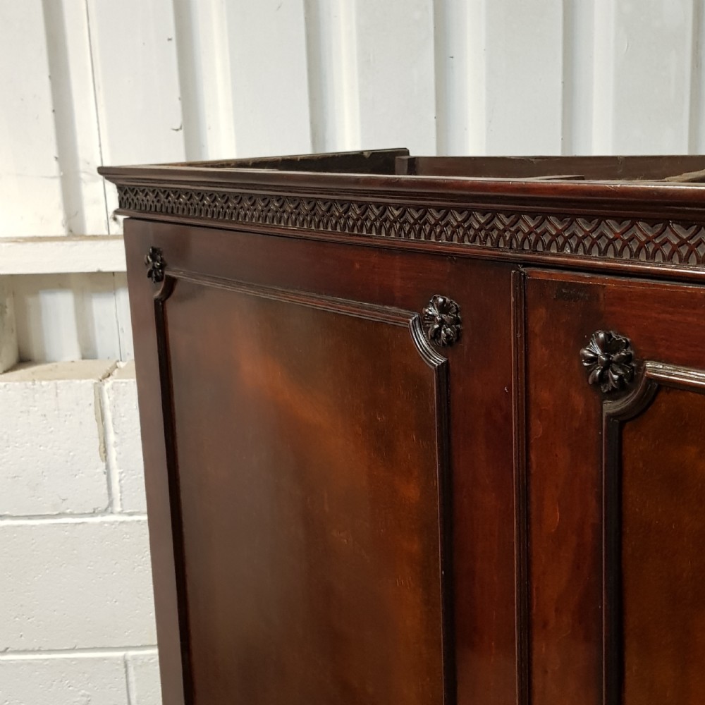 An eighteenth-century mahogany double wardrobe featuring flame mahogany panel doors decorated with carved corner rosettes and resting on bracket feet. View VII