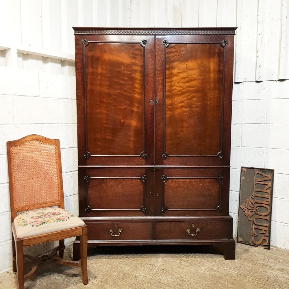 An eighteenth-century mahogany double wardrobe featuring flame mahogany panel doors decorated with carved corner rosettes and resting on bracket feet. View IX