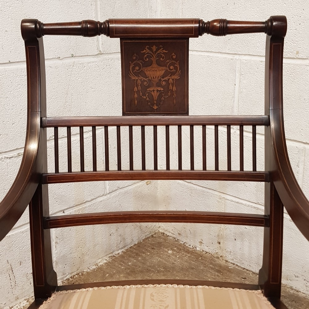 A pair of Edwardian mahogany armchairs featuring inlaid marquetry backsplats, vertical spindles, sweeping armrests, and striped fabric upholstery. View III