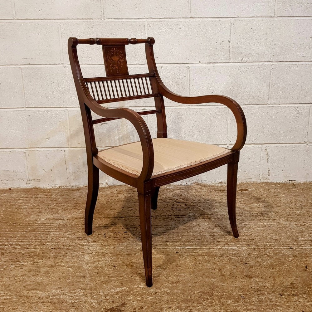 A pair of Edwardian mahogany armchairs featuring inlaid marquetry backsplats, vertical spindles, sweeping armrests, and striped fabric upholstery. View VI