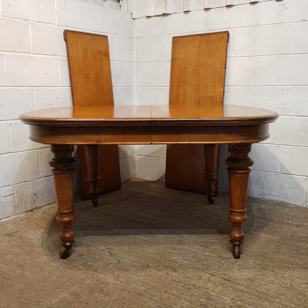 AN ANTIQUE VICTORIAN OAK EXTENDING WIND OUT DINING TABLE WITH TWO EXTRA LEAVES View III