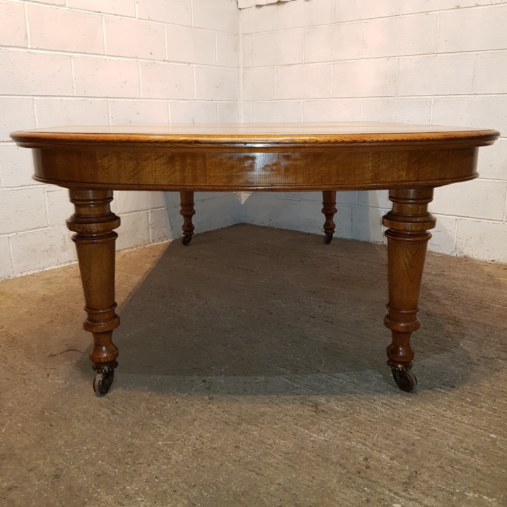 AN ANTIQUE VICTORIAN OAK EXTENDING WIND OUT DINING TABLE WITH TWO EXTRA LEAVES View V
