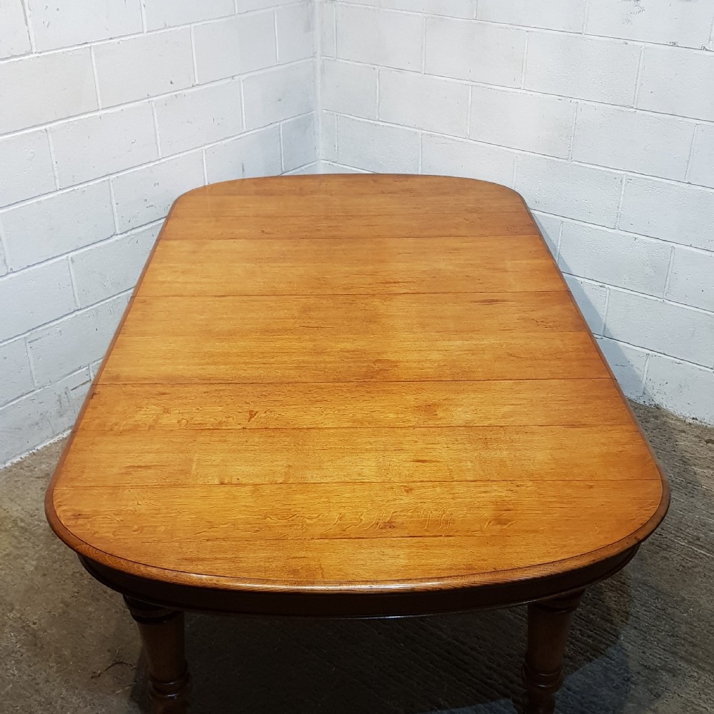 AN ANTIQUE VICTORIAN OAK EXTENDING WIND OUT DINING TABLE WITH TWO EXTRA LEAVES View VII