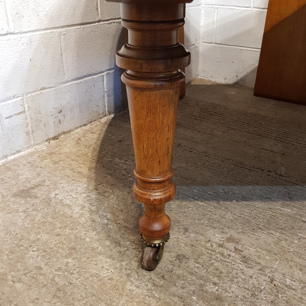 AN ANTIQUE VICTORIAN OAK EXTENDING WIND OUT DINING TABLE WITH TWO EXTRA LEAVES View VIII