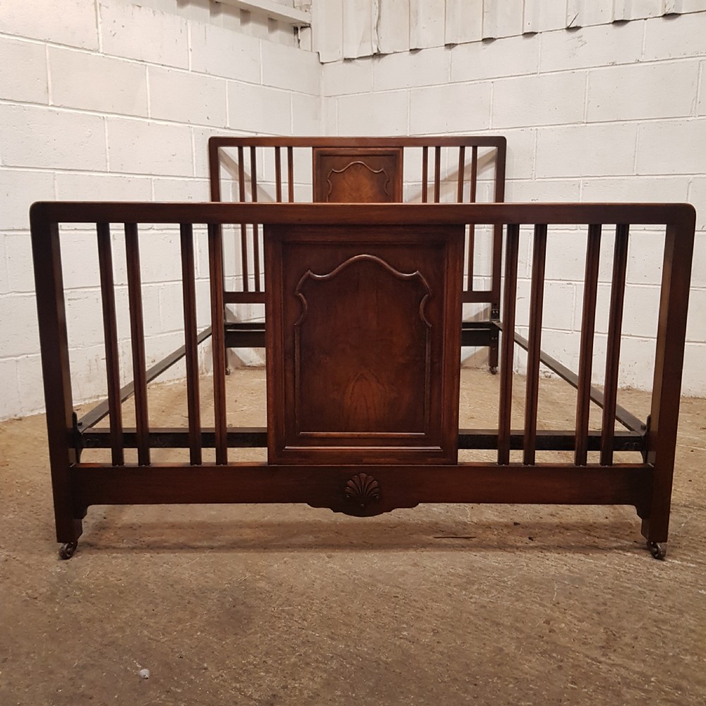 An antique dark walnut double bedstead featuring a central arched panel flanked by vertical slats on both the headboard and footboard, set with metal side rails. View II