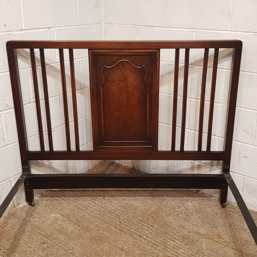 An antique dark walnut double bedstead featuring a central arched panel flanked by vertical slats on both the headboard and footboard, set with metal side rails. View V
