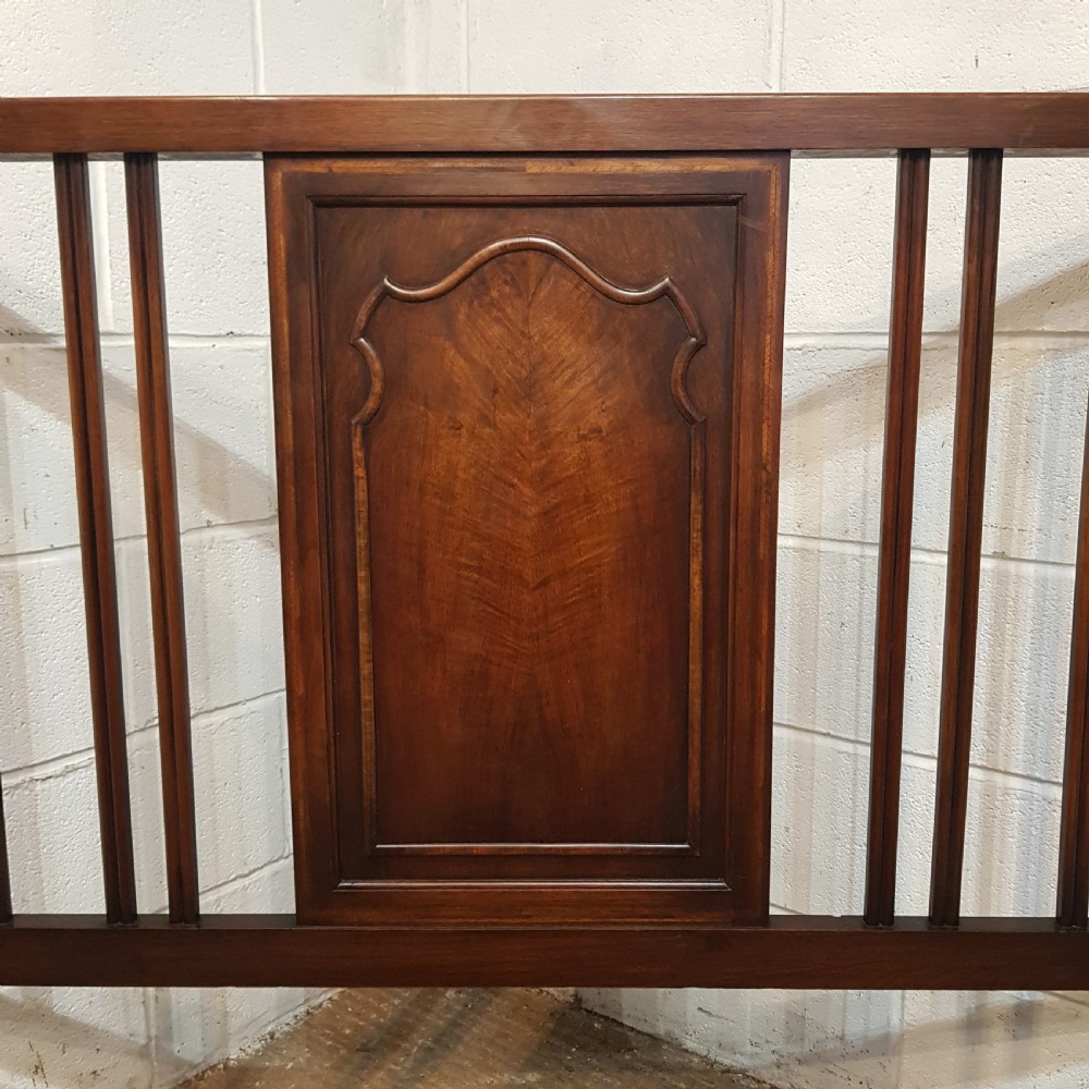 An antique dark walnut double bedstead featuring a central arched panel flanked by vertical slats on both the headboard and footboard, set with metal side rails. View VI