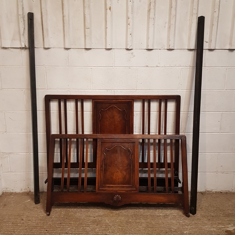An antique dark walnut double bedstead featuring a central arched panel flanked by vertical slats on both the headboard and footboard, set with metal side rails. View VIII