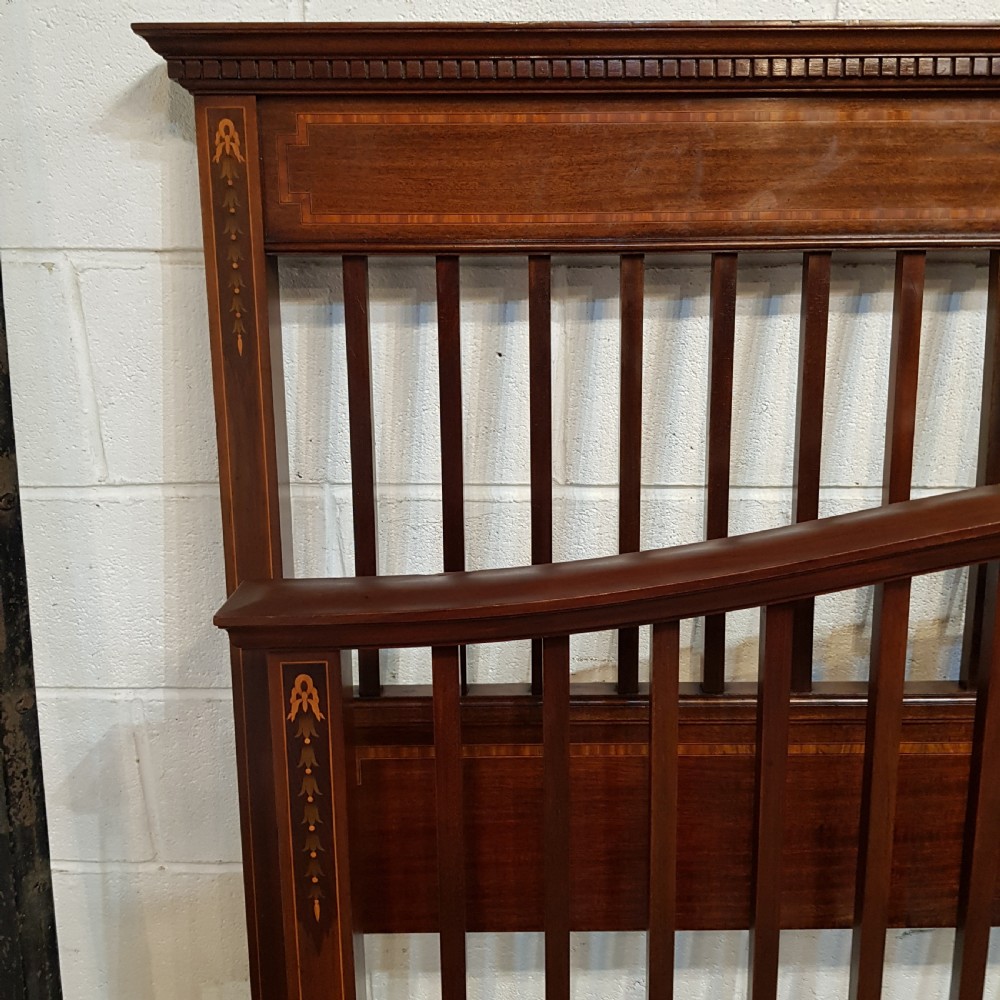 An Edwardian mahogany king size bedstead featuring vertical slatted panels on both headboard and footboard, decorated with fine wood inlay. View VII