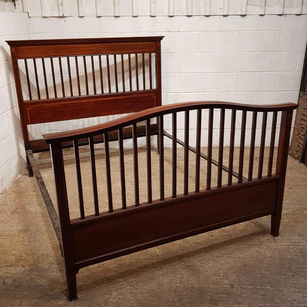 An Edwardian mahogany king size bedstead featuring vertical slatted panels on both headboard and footboard, decorated with fine wood inlay. View VIII