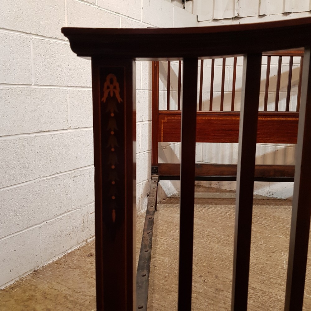 An Edwardian mahogany king size bedstead featuring vertical slatted panels on both headboard and footboard, decorated with fine wood inlay. View IX