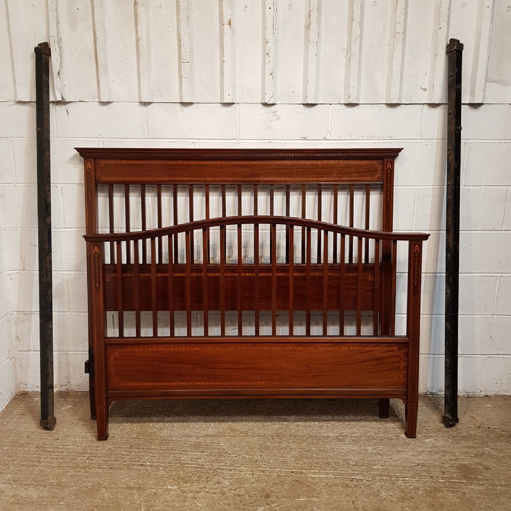 An Edwardian mahogany king size bedstead featuring vertical slatted panels on both headboard and footboard, decorated with fine wood inlay. View X