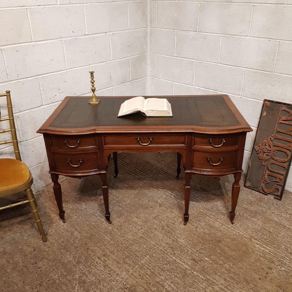 A LARGE EDWARDIAN MAHOGANY SERPENTINE FRONTED DESK C1900