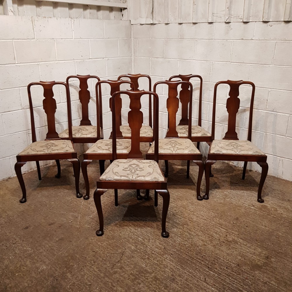 A set of eight mahogany Queen Anne style dining chairs featuring vase-shaped back splats, cabriole front legs, and patterned upholstered seats.
