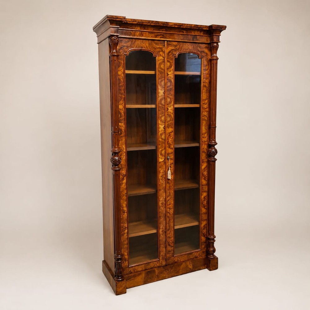 A TALL AND NARROW BURR WALNUT GLAZED BOOKCASE C1850