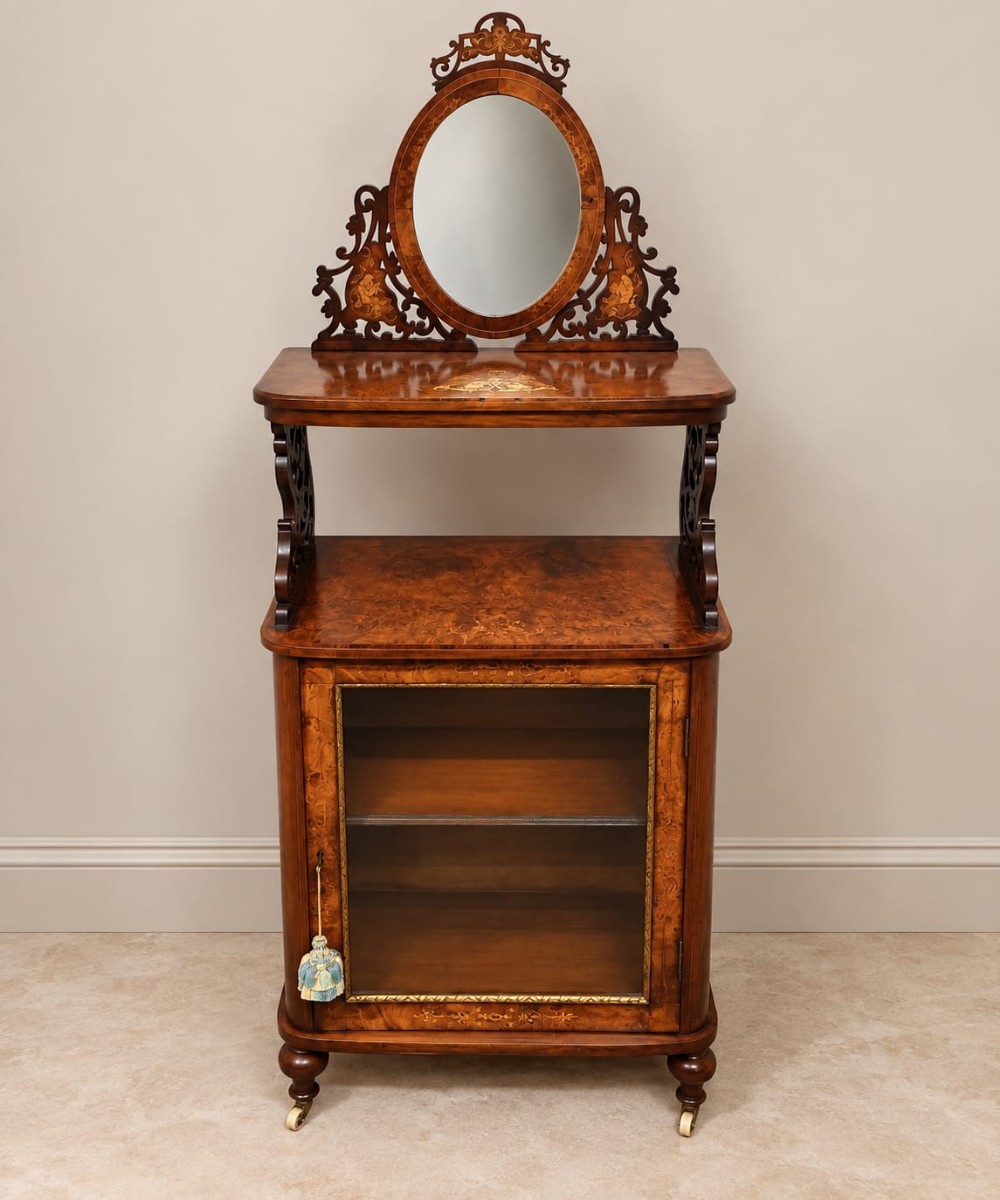 A Victorian burr walnut side cabinet with a glazed single door, marquetry inlay details, an upper shelf tier, and an oval mirror crest.