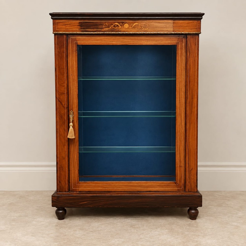 A late 19th-century Victorian rosewood pier cabinet featuring a glazed single door, brass beaded moulding, inlaid foliate marquetry, and a blue fabric-lined interior with glass shelves.