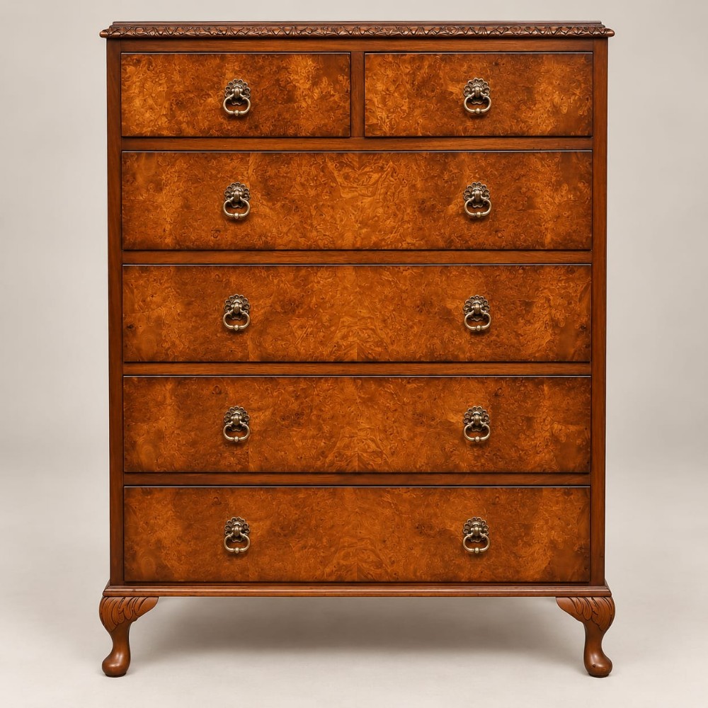 A 1920s burr walnut chest of drawers featuring five drawer tiers with brass drop handles and carved cabriole legs.