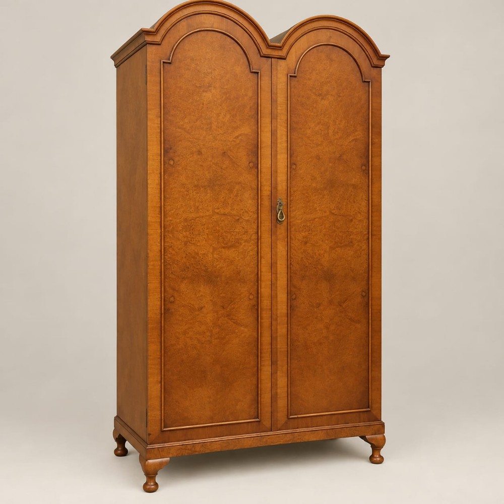 A 1920s burr walnut double wardrobe with a double-domed top, twin arched panel doors, and short shaped feet.